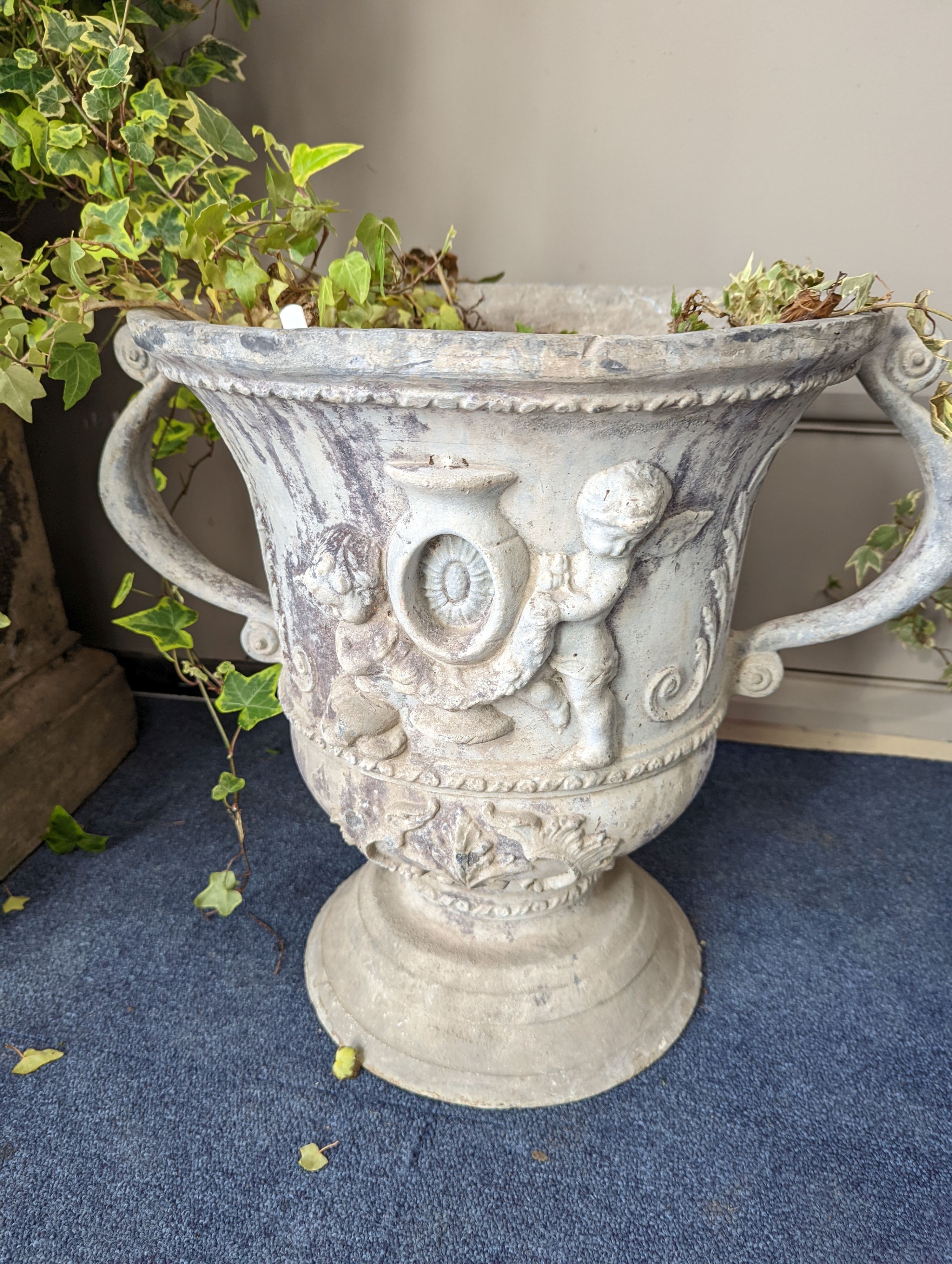 A set of three Victorian lead two handled garden planters, moulded with cherubs, diameter 38cm, height 43cm